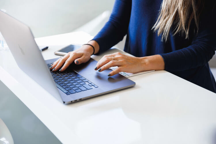 Mujer escribiendo un correo electrónico en ordenador portátil